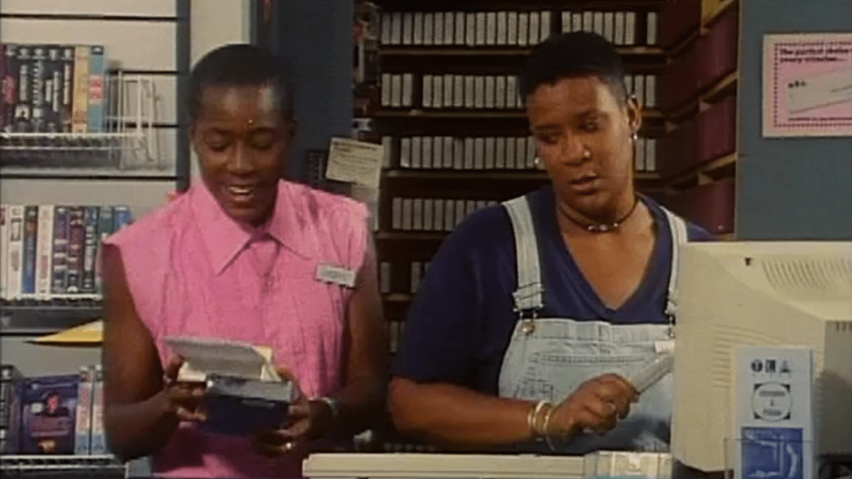 two women at video store behind check out counter
