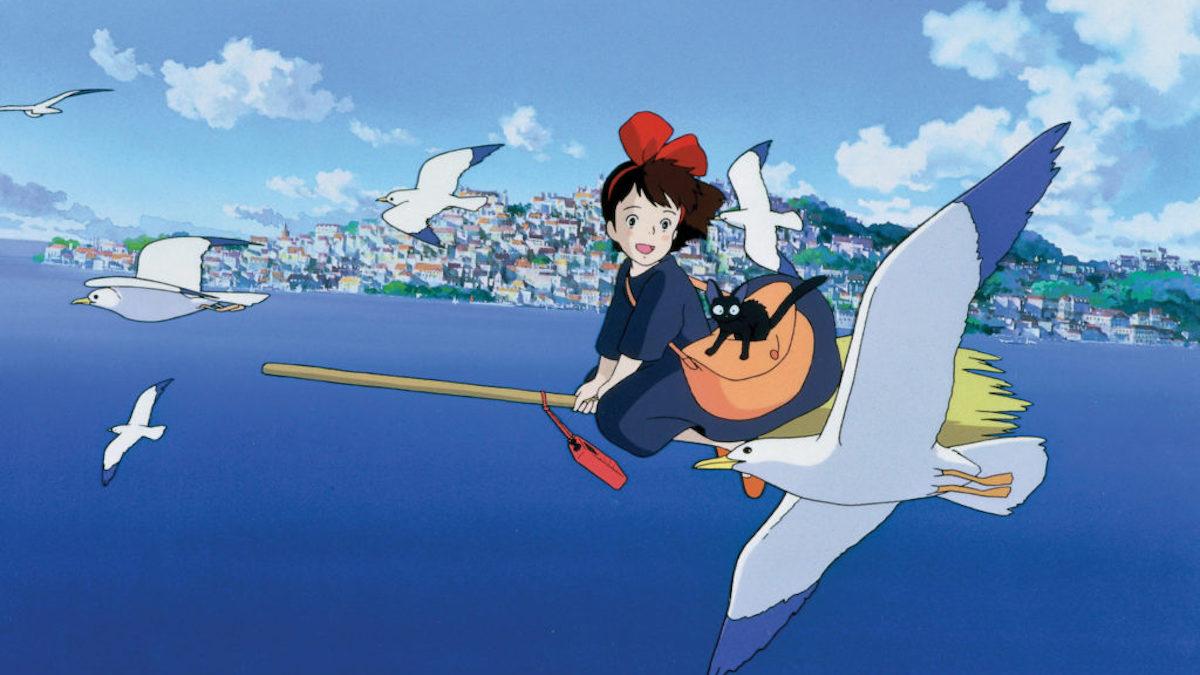 girl riding on broom over sea with small black cat