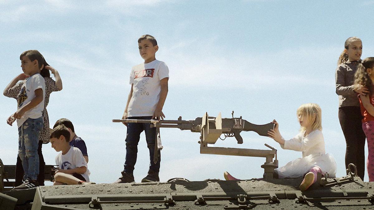 children on top of a rooftop with rifle