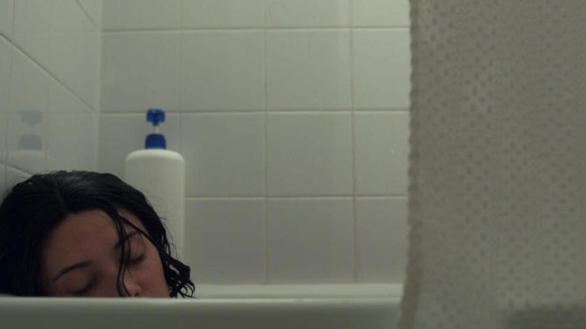woman leaning in bathtub with eyes closed