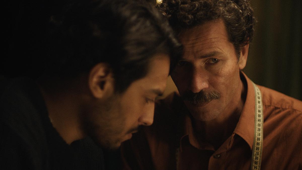 close up of two men talking in the dark