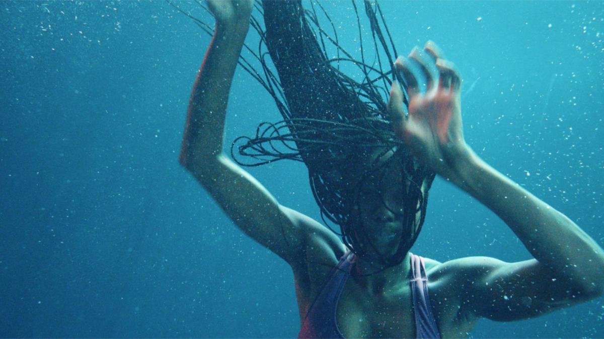 woman under water with hair and arms up 