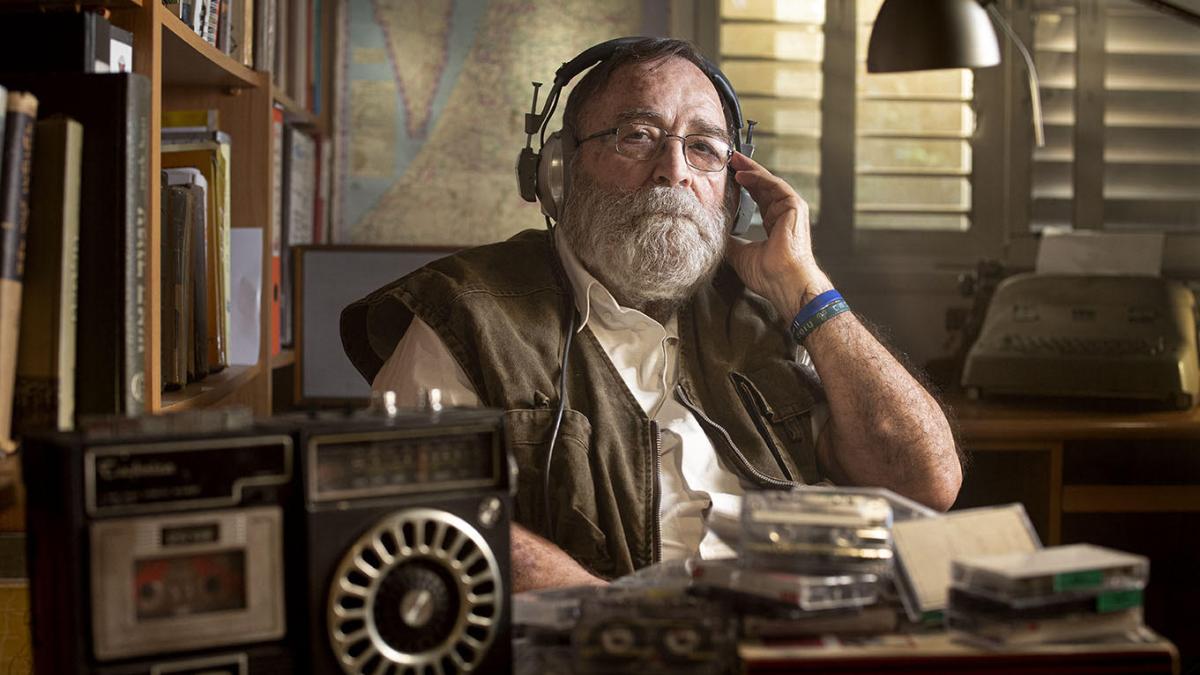 man sitting at desk with headphones on