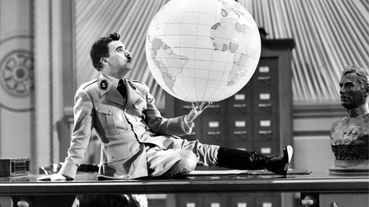 man in military uniform holding up large globe