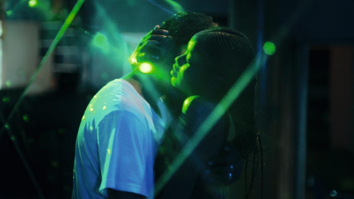 couple dancing in dark club with green spotlights around them