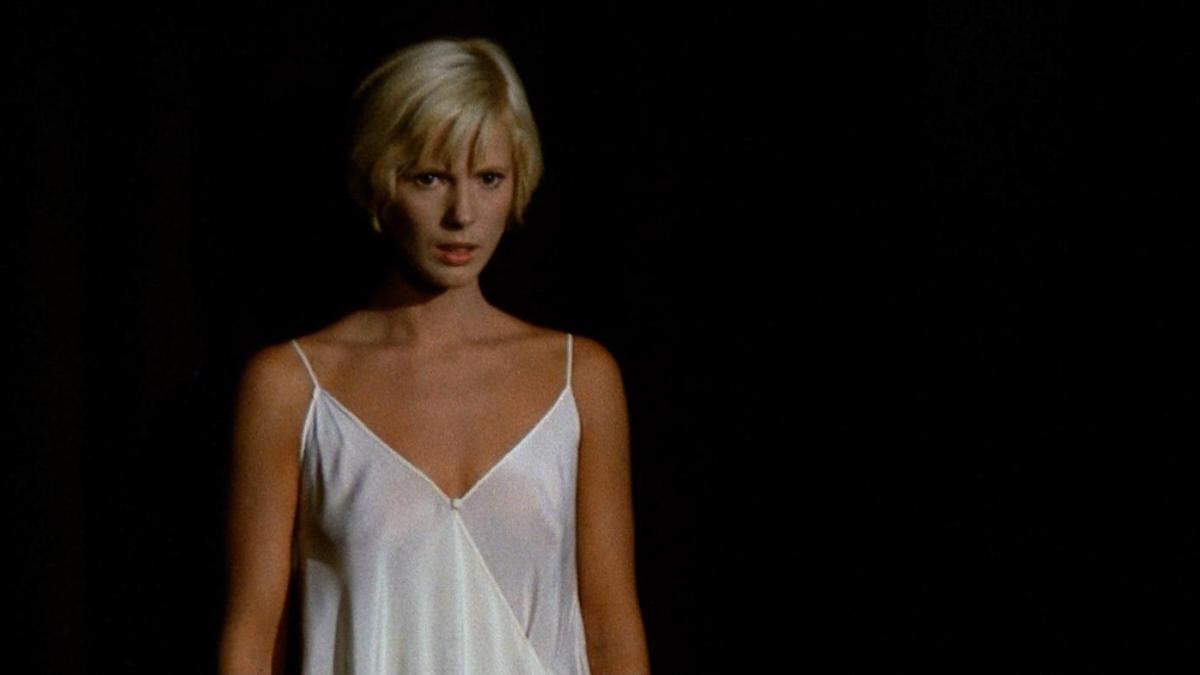 woman in white nightgown against black backdrop