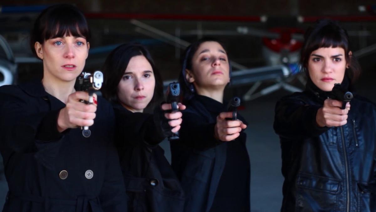 Four young people wearing black and pointing guns