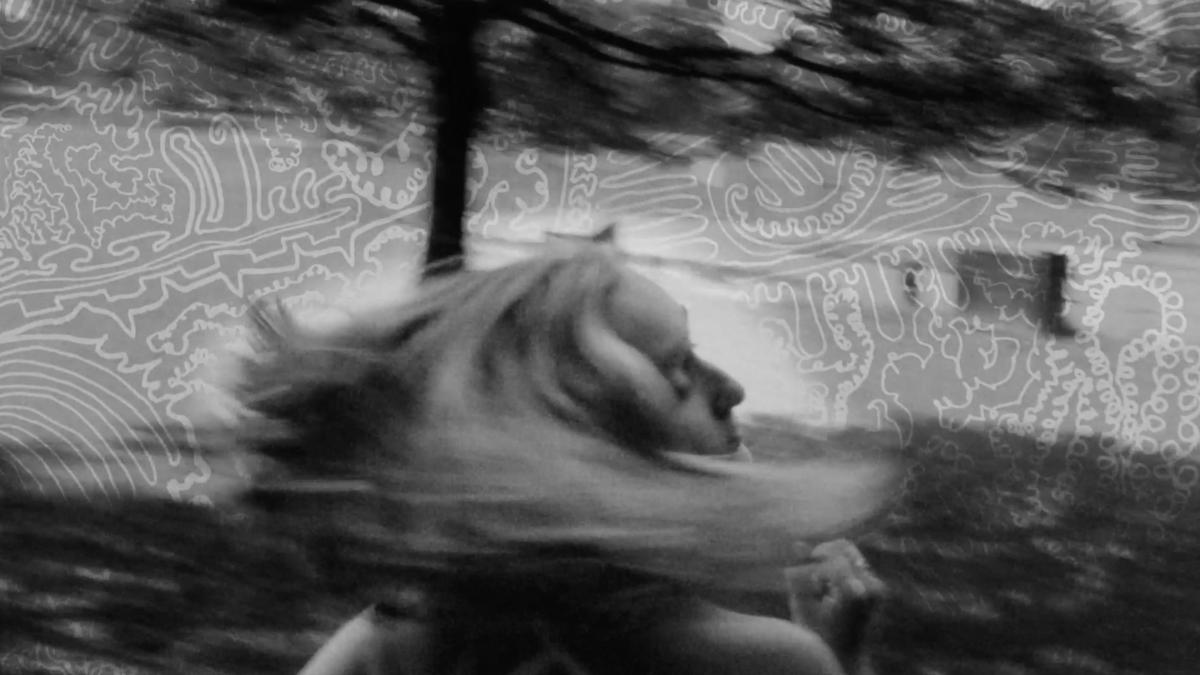 black and white photo of blonde woman swirling hair around