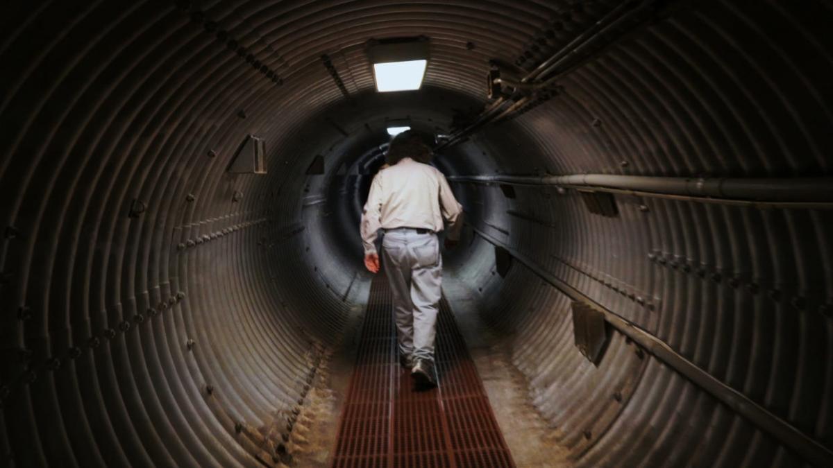 man walking through underground tunnel