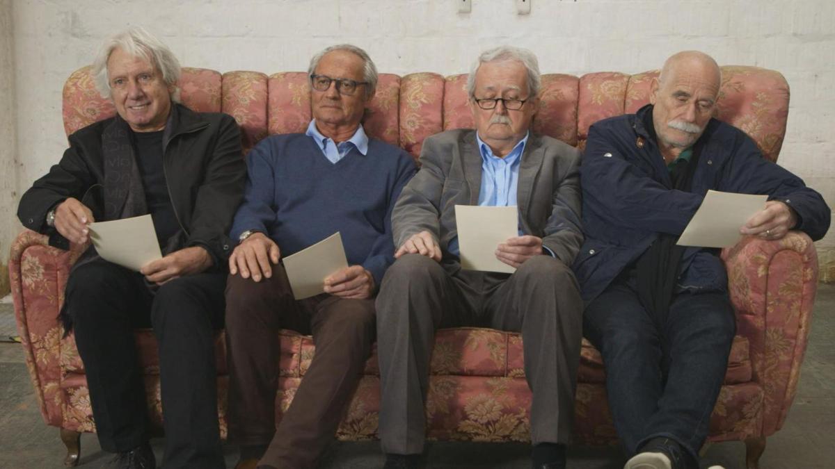 four elder men sitting on couch together