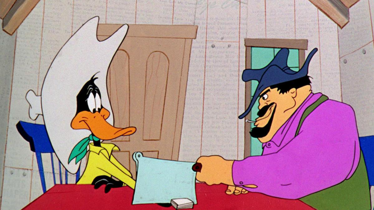 Looney Tunes with Daffy Duck wearing large hat seated at table with bearded man