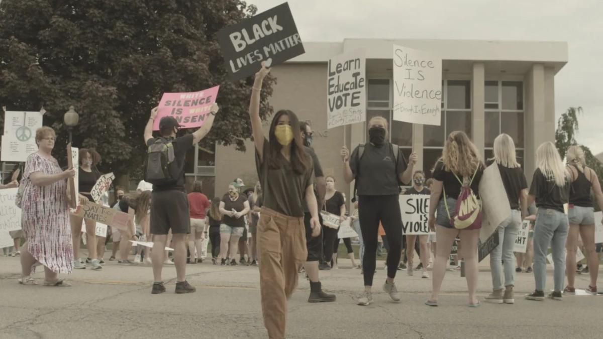 people protesting outside holding signs