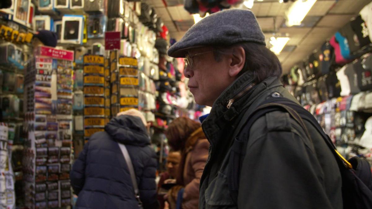 man standing in shop wearing hat and coat