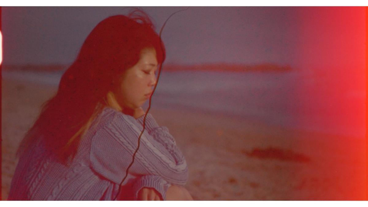 woman sitting on beach looking down