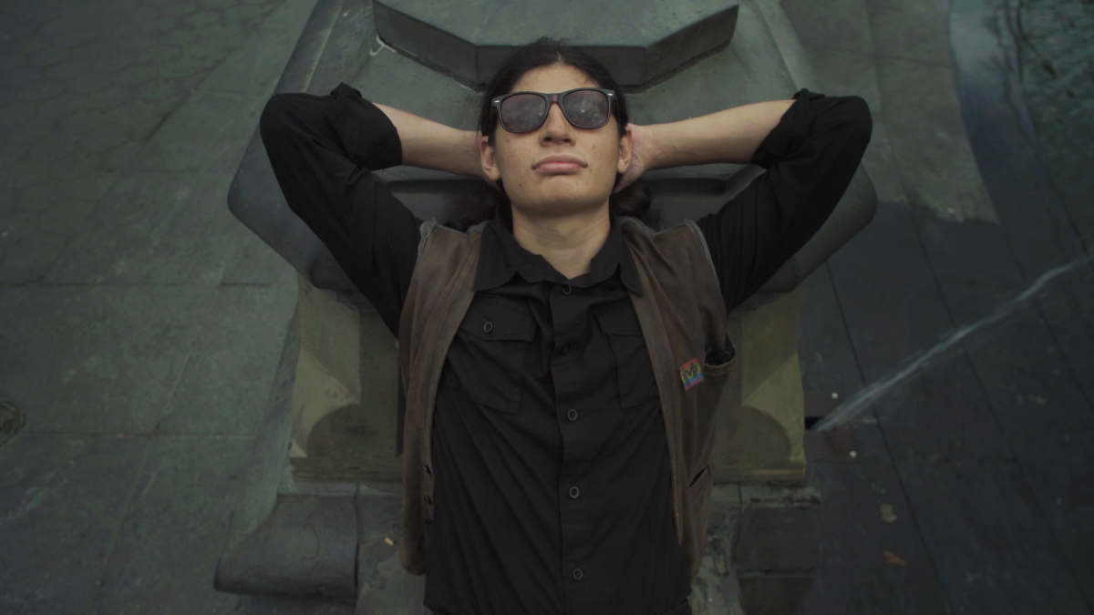 man wearing sunglasses laying on back with hands behind head