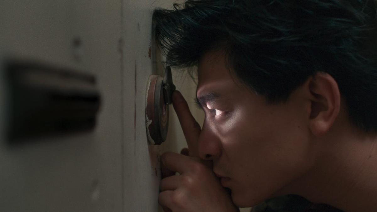 man peering through peep hole