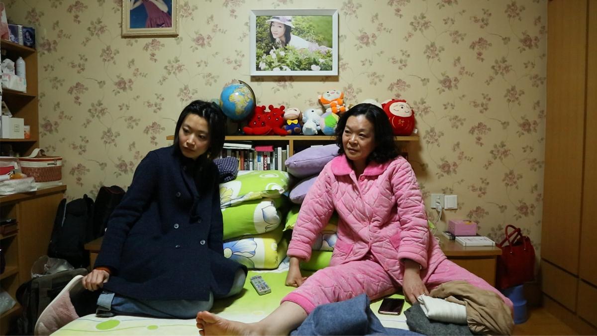 two woman in pajamas sitting on bed