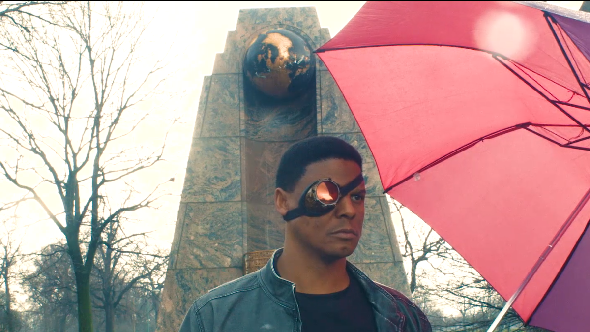 man standing on city street with pink umbrella