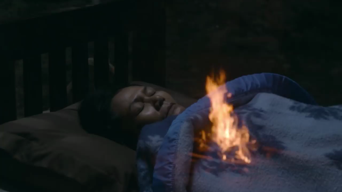 woman lying in bed with fire coming from chest
