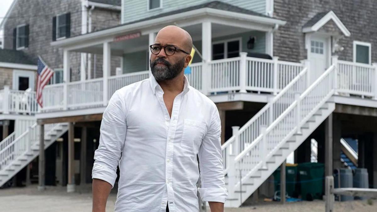 man standing in front of beach house wearing white button down shirt and glasses