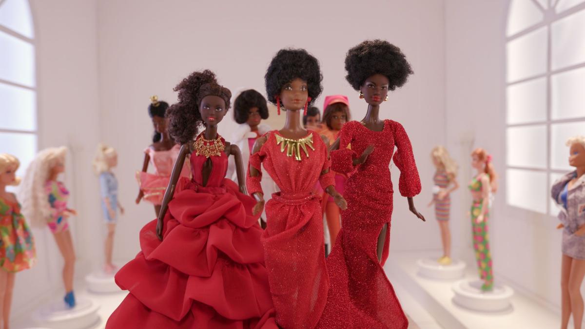 Black Barbie dolls wearing red evening wear
