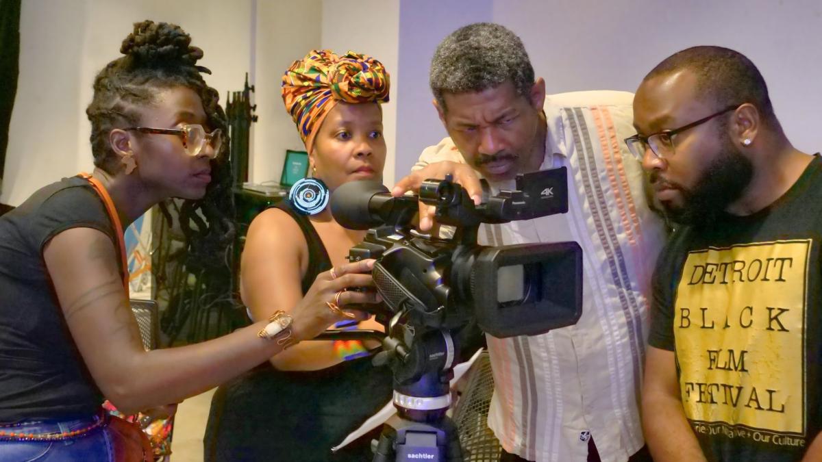 four people looking at screen of camera