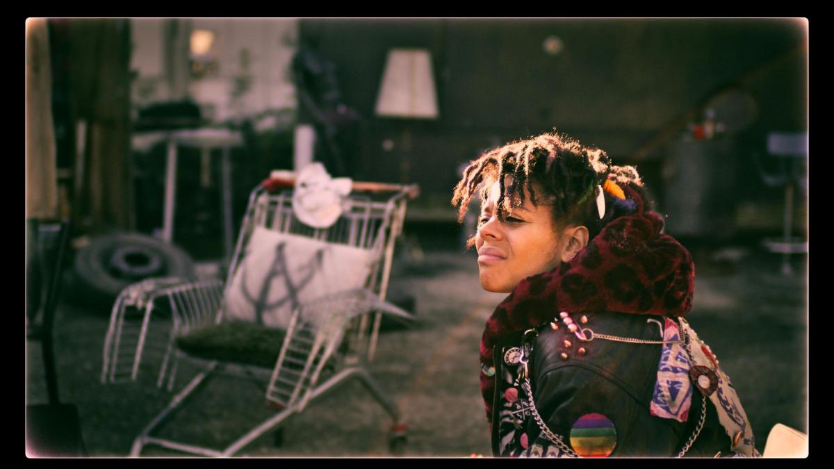 person sitting outside in sun looking in distance