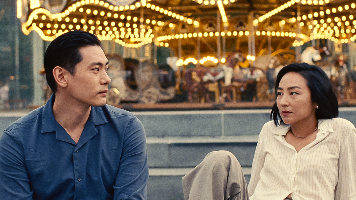 man and woman sitting in front of carousel 