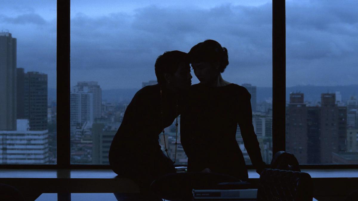 silhouette of couple in front of large window with city view