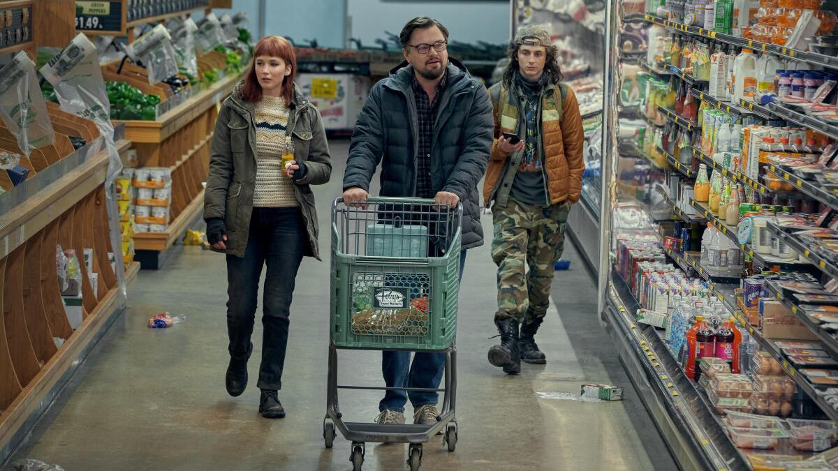 three people walking through grocery store aisle