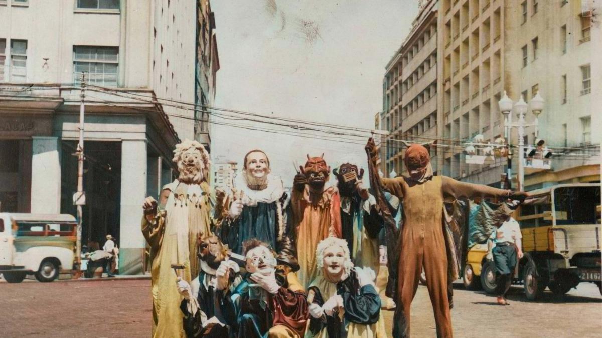 people dressed up in clown costumes standing in street intersection