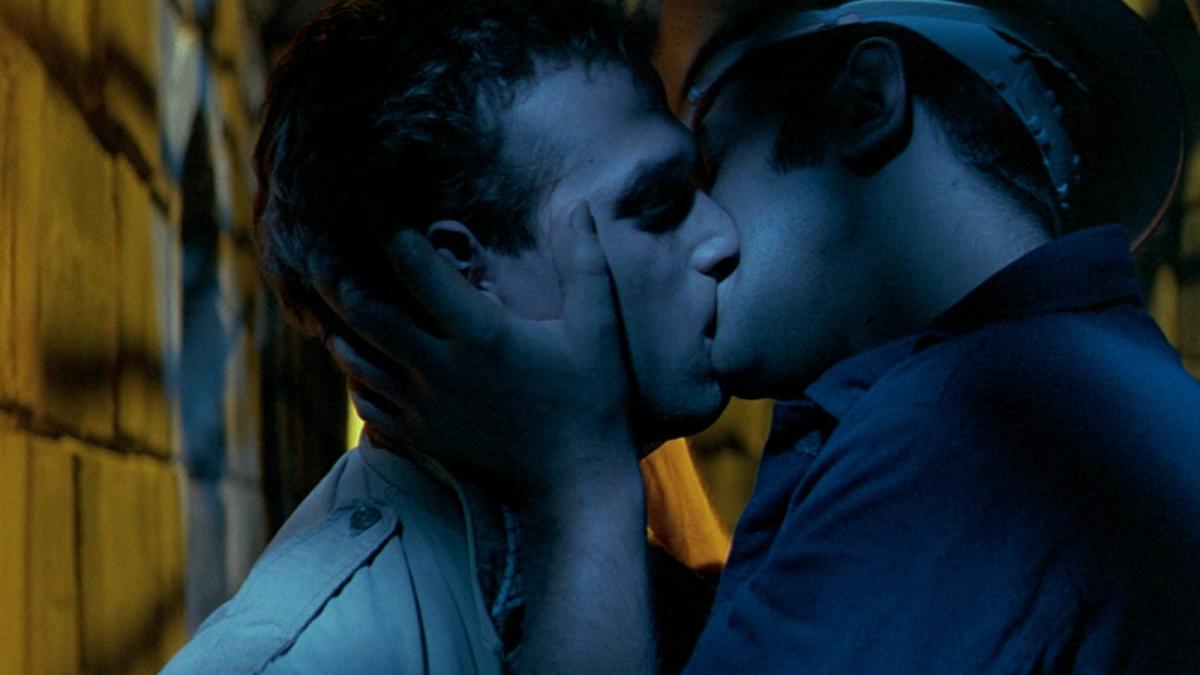 two men kissing in dark