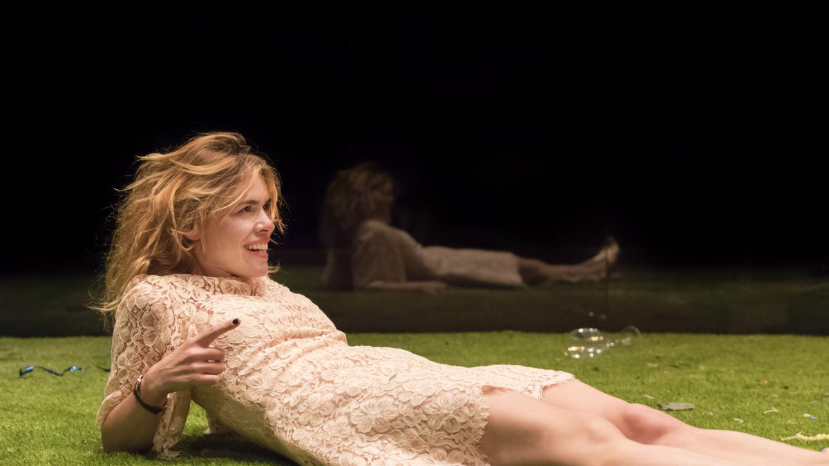 woman wearing floral dress leaning back in grass