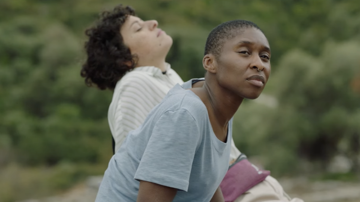 two woman sitting next to each other outside