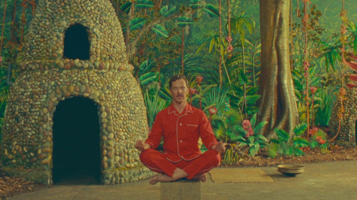 man wearing red sitting and meditating in forest