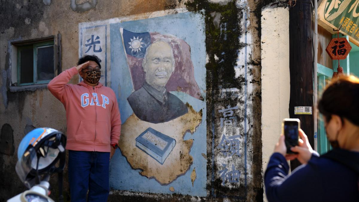 person posing next to street art with hand saluting