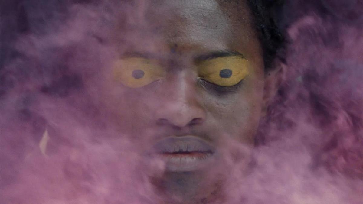 black man with yellow eyes and purple smoke enveloping face