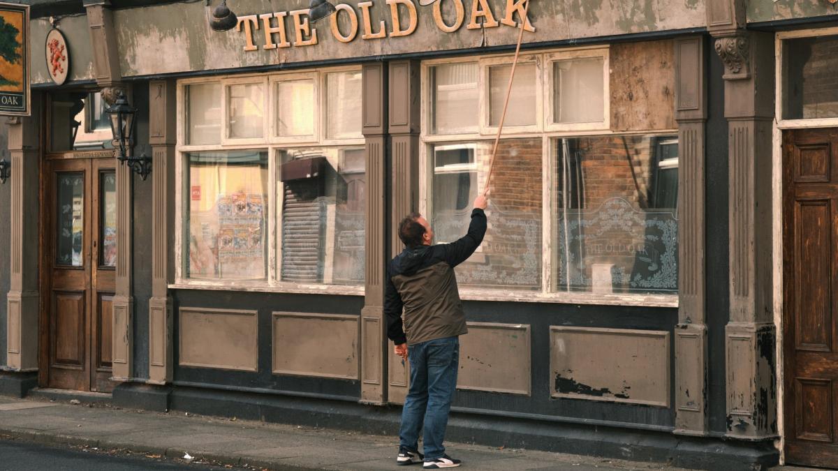 man standing outside of bar front