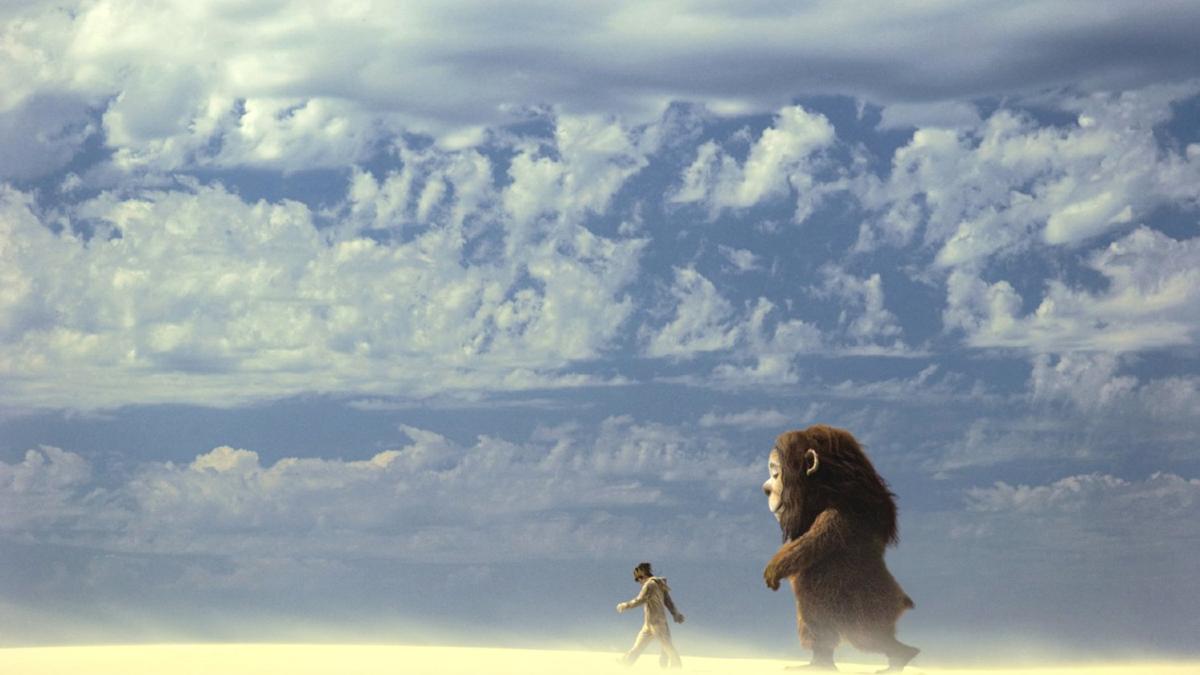 large monster and boy walking through desert 