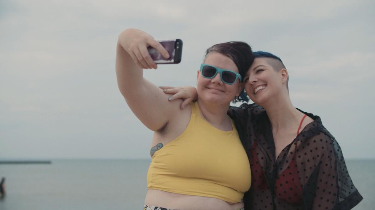 two girls taking selfie in front of lake