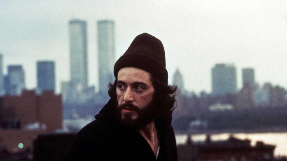 man wearing beanie outside with twin towers in the background
