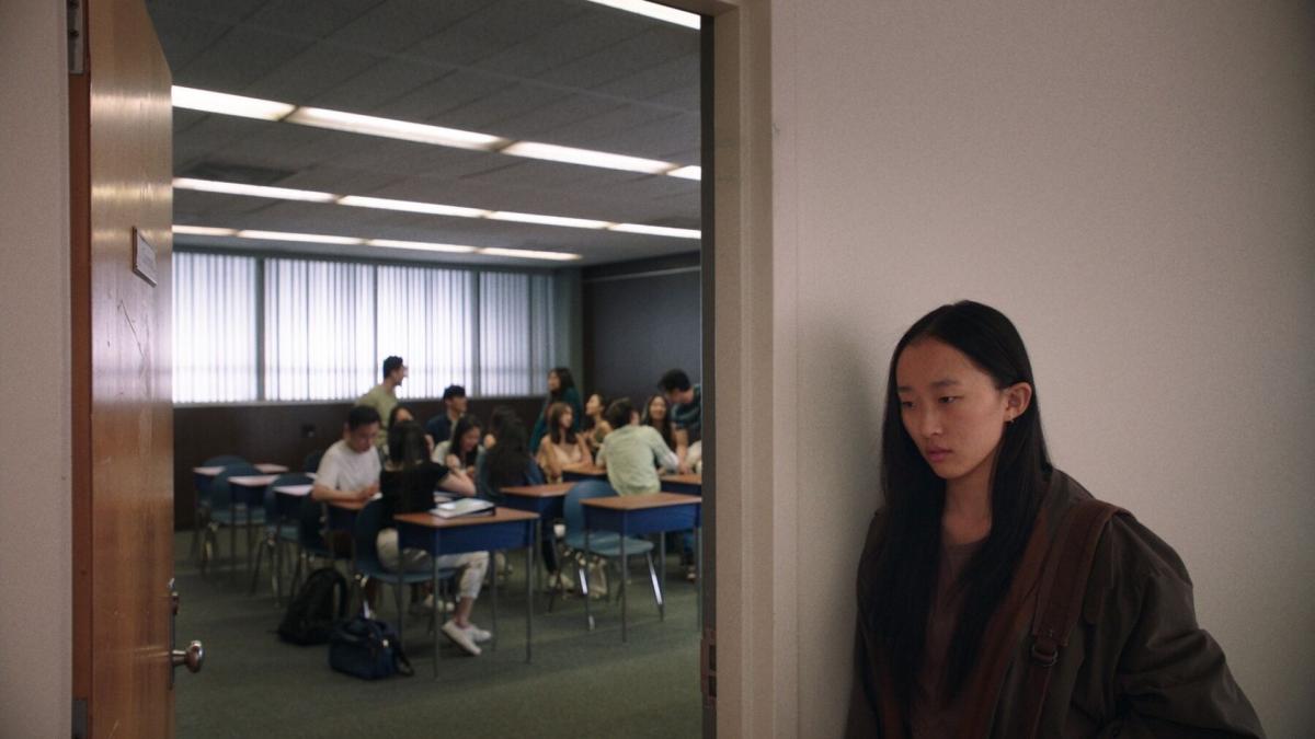 young girl standing in hallway outside of meeting room listening in