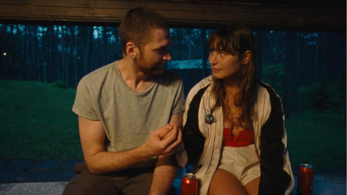 man and woman sitting on ledge outside at night