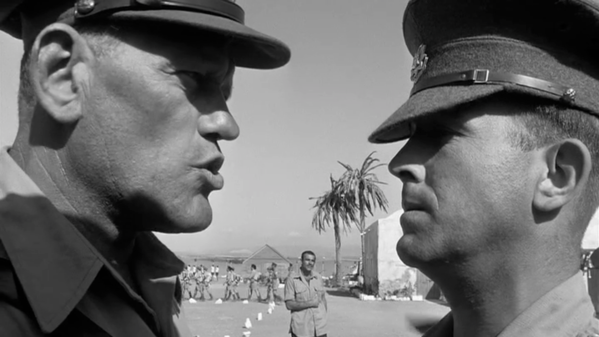 two men in military uniforms standing close talking