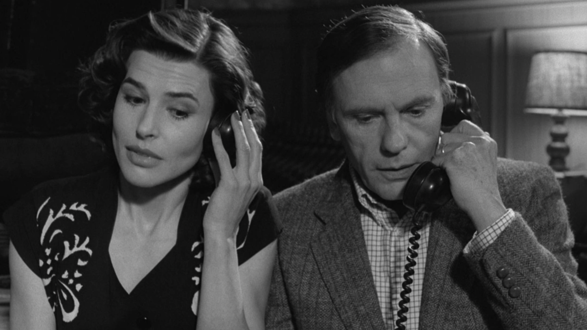 man and woman seated next to each other talking into phone