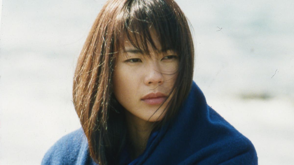 girl on beach with blue sweater