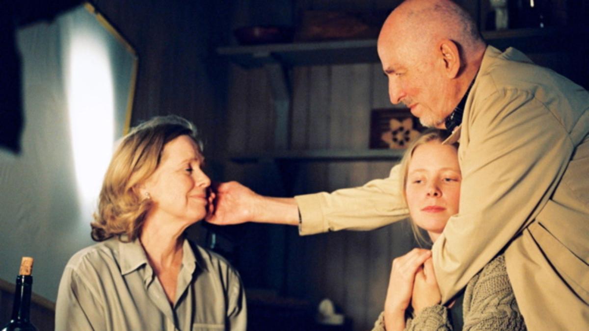 man hugging girl and reaching out touching woman's cheek