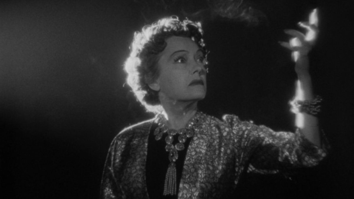 woman in sparkly dress holding hand up 