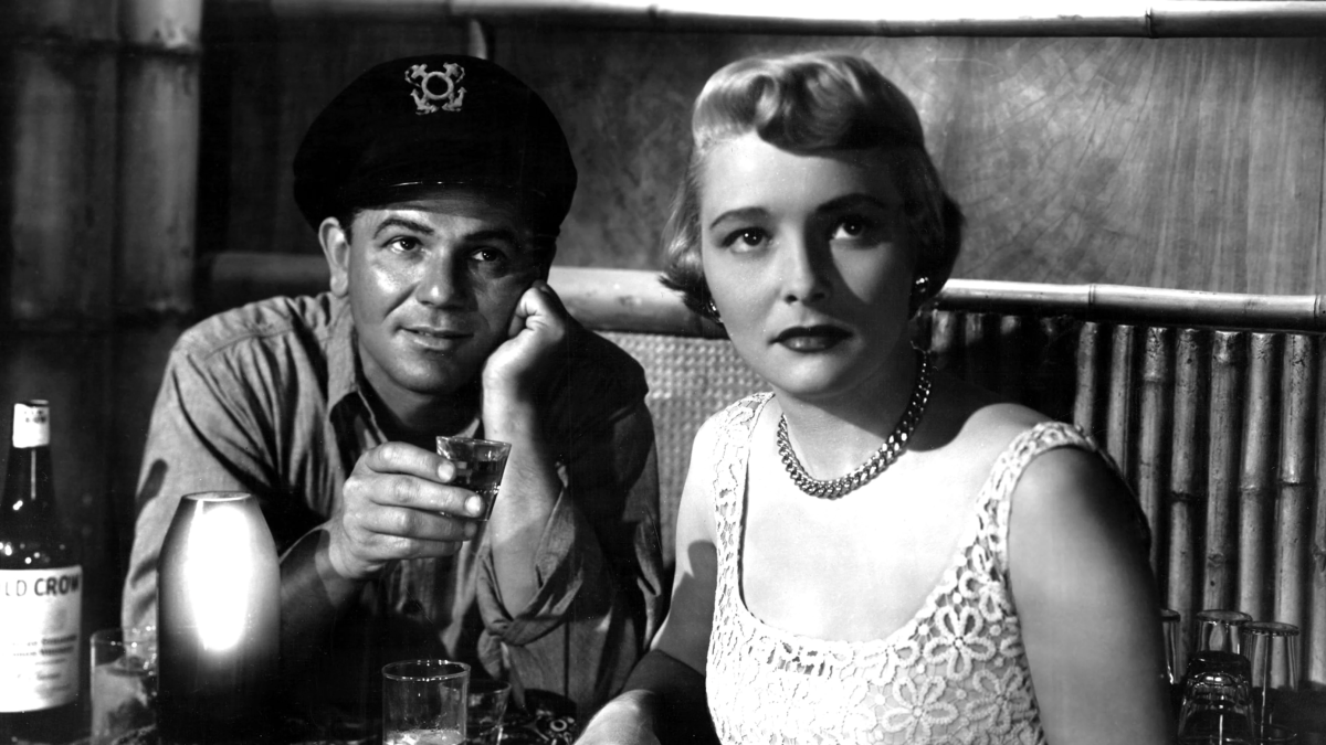 man in military uniform and woman in dress sitting at table