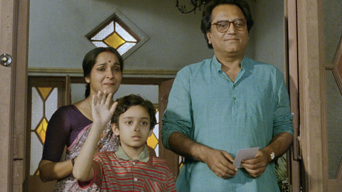 family standing together at front door waving